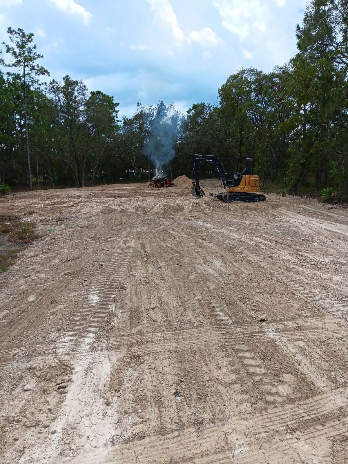 Excavator working on cleared land